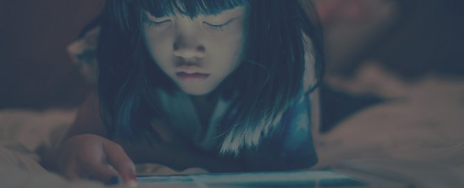 A young Asian girl using an tablet.